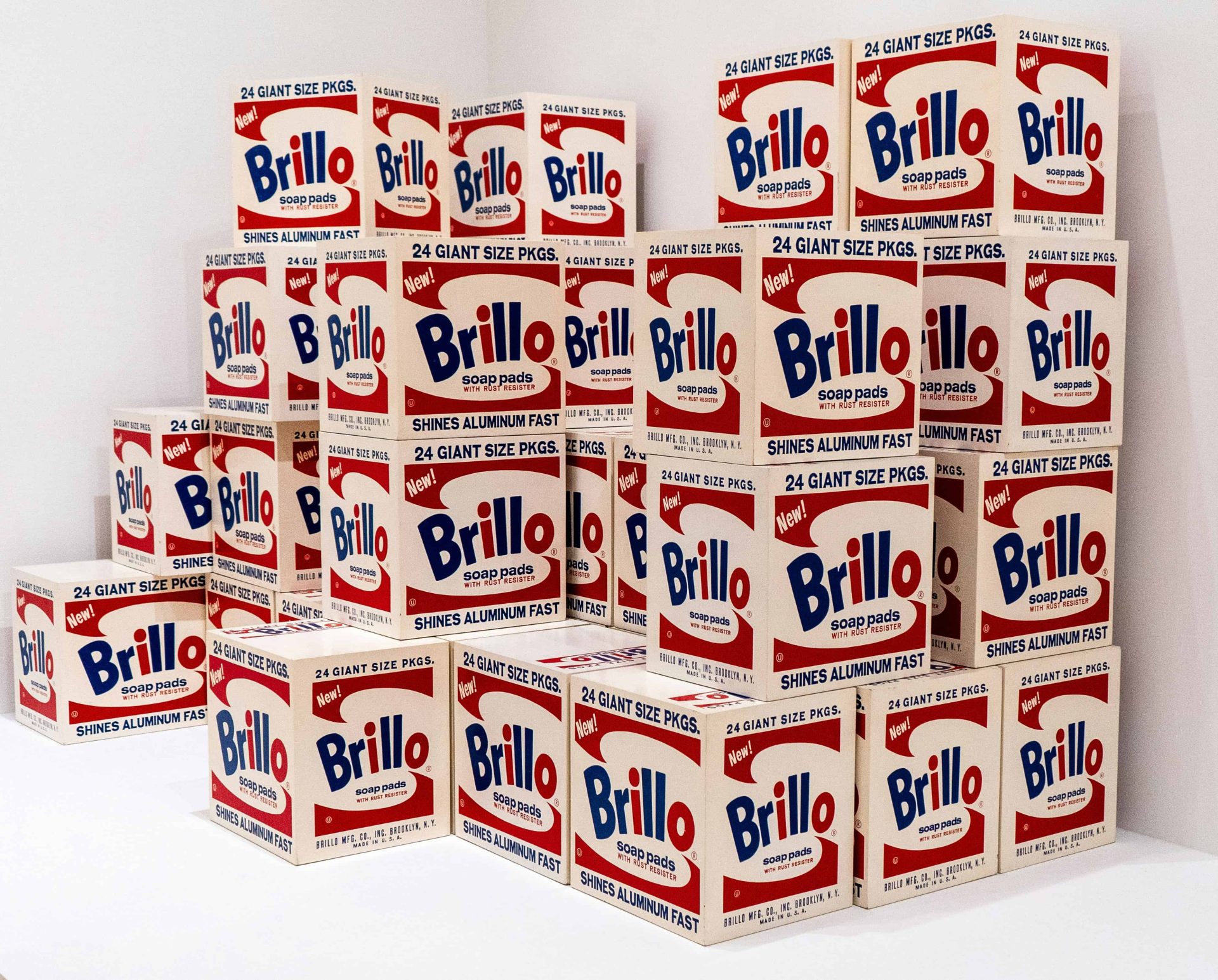 Stack of Andy Warhol's Brillo Boxes displayed in a museum exhibition.